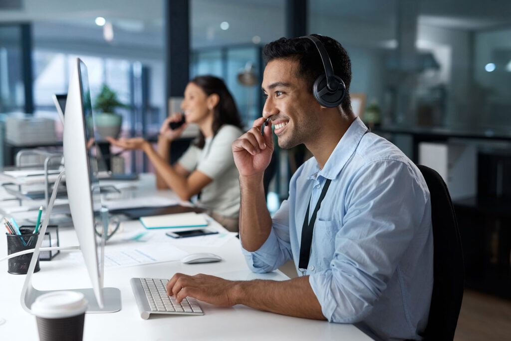 a young man using a headset and computer voip